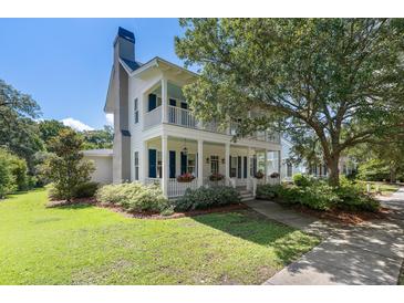 Charming two-story home features a double porch, manicured landscaping, and lovely curb appeal at 3426 Acorn Drop Ln, Johns Island, SC 29455