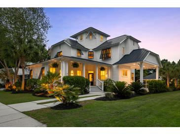 Stunning two-story white home featuring a welcoming front porch and beautifully landscaped front yard at 4009 E Amy Ln, Johns Island, SC 29455