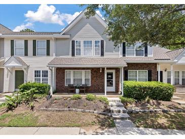 Charming brick and siding townhome featuring a cozy front porch and manicured landscaping at 432 Doane Way, Wando, SC 29492