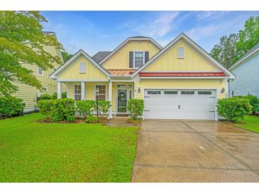 Charming yellow home with a well-maintained lawn and attached two-car garage at 493 Nelliefield Trl, Wando, SC 29492