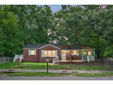 Charming single-story brick home with light blue shutters nestled among mature trees at 5056 Piedmont Ave, North Charleston, SC 29406