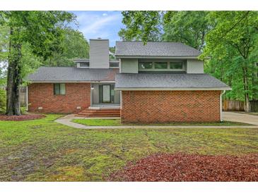 A two-story brick home has modern architectural details and mature landscaping at 105 Londonderry Rd, Goose Creek, SC 29445