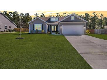 Charming single-story home with a well-manicured lawn, attached garage, and inviting curb appeal at 1144 Wading Point Blvd, Huger, SC 29450