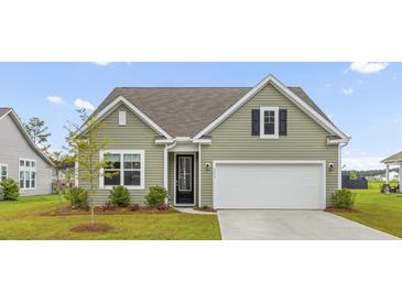 Charming home featuring green siding, a white garage door, and a well-manicured lawn at 1173 Wading Point Blvd, Huger, SC 29450
