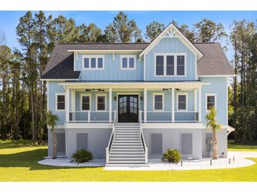 Charming two-story home with a inviting front porch and a well-manicured lawn and a beautiful garden at 1327 Wood Sorrel Dr, Moncks Corner, SC 29461