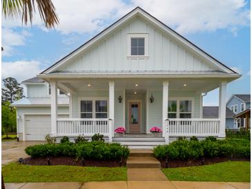 Charming, light blue home with a covered front porch, white columns, and manicured landscaping at 1740 Agate Bay Dr, Mount Pleasant, SC 29466