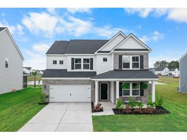 Charming two-story home with brick and white siding, a well-manicured lawn, and a two-car garage at 211 Squire Pope Rd, Summerville, SC 29486