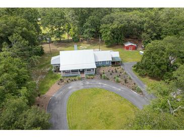 Beautiful aerial view of a charming country home with a white metal roof and a well manicured lawn at 225 Baxter Ln, Walterboro, SC 29488
