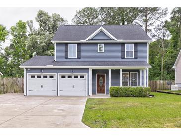 Charming two-story home with an attached two-car garage and a well-manicured front lawn at 321 Houston Dr, Ladson, SC 29456