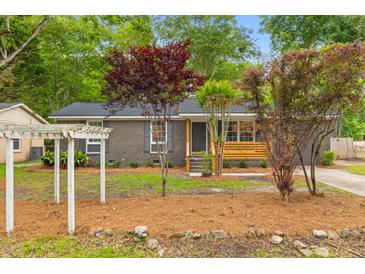 Charming single-story brick home with well-manicured landscaping and inviting front porch at 411 Berkeley Dr, Moncks Corner, SC 29461