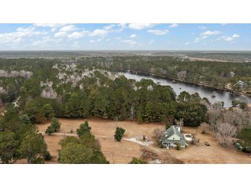 Expansive aerial view of home on large lot surrounded by lake and woods at 4689 Causey Pond Rd, Awendaw, SC 29429