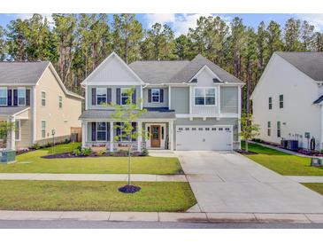 Charming two-story home featuring a manicured lawn, inviting porch, and a two-car garage in a Gathering-friendly neighborhood at 596 Dunswell Dr, Summerville, SC 29486
