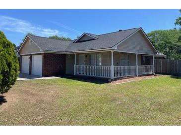 Charming single-story home with a well-maintained lawn and attached two-car garage at 7733 Buck Pond Rd, North Charleston, SC 29418