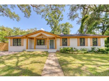 Charming single-story home featuring a white brick exterior, wood accents, and a beautifully landscaped front yard at 841 Fred St, Charleston, SC 29412