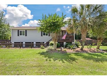 Charming home with manicured lawn, mature trees, and inviting front porch with stairs leading to the front door at 1125 Oceanview Rd, Charleston, SC 29412