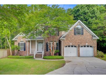 Charming brick home with a well-manicured lawn, mature tree, and attached two-car garage at 1851 Oleander Ct, Charleston, SC 29414