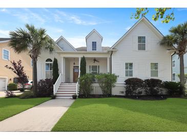 Charming two-story white home featuring a beautifully landscaped yard and inviting front porch at 2141 Sandy Point Ln, Mount Pleasant, SC 29466