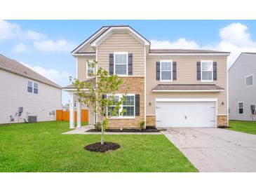 Inviting two-story home featuring a well-manicured lawn, stone accents, and an attached two-car garage at 241 Wathen Dr, Goose Creek, SC 29445