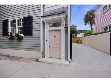 Charming home featuring a pink front door with a window box and driveway at 29 Bogard St, Charleston, SC 29403