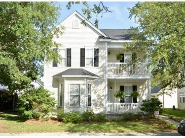 Charming two-story home with double balconies, a manicured lawn, and mature trees at 30 Regency Oaks Dr, Summerville, SC 29485