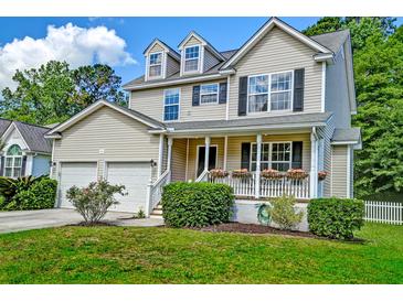Charming two-story home features a welcoming front porch and well-maintained landscaping at 3073 Penny Ln, Johns Island, SC 29455