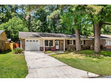 Quaint brick home with well-kept lawn, a driveway, and a welcoming entrance with chairs at 315 Elliott Dr, Ladson, SC 29456