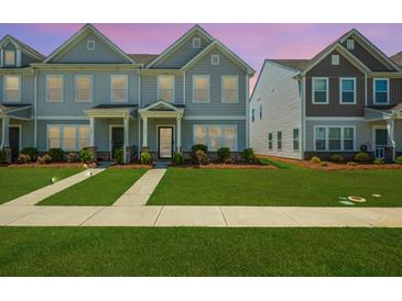 Charming townhome with gray siding, well-manicured lawn and sidewalks leading to covered entryway at 326 Surfbird Rd # 388, Summerville, SC 29486