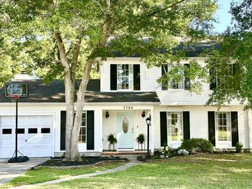 Charming two-story home featuring a manicured lawn, light blue front door and a basketball hoop over the garage at 3784 Scotts Mill Dr, North Charleston, SC 29420