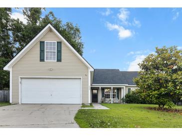 Inviting tan home with a spacious two-car garage, green shutters, and a well-manicured front yard at 402 Equinox Cir, Ladson, SC 29456