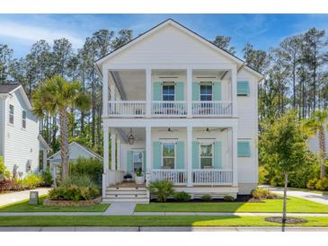 Charming two-story home with double porches, complemented by lush landscaping and classic white facade at 4114 Maidstone Dr, Mount Pleasant, SC 29466