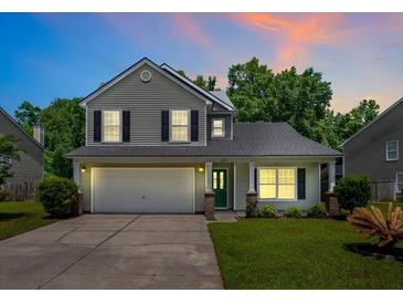 Charming two-story home featuring a well-manicured lawn, two car garage and beautiful, mature landscaping at 4977 Ballantine Dr, Summerville, SC 29485