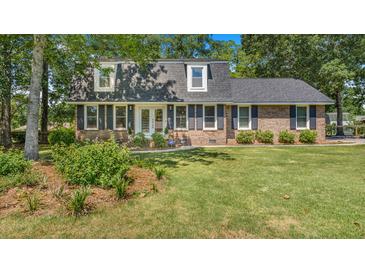 Charming two-story brick home with a well-manicured lawn, black shutters, and dormer windows at 122 Mellard Dr, Goose Creek, SC 29445