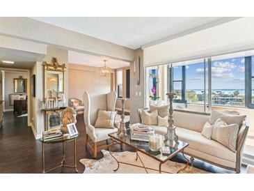 Bright living room features stylish seating, glass tables, and stunning views of the water at 14 Lockwood Dr # 4C, Charleston, SC 29401