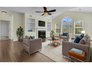 Bright living room features a ceiling fan, fireplace, hardwood floors, and a large window at 1631 Camfield Ln, Mount Pleasant, SC 29466