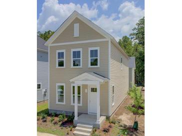 Charming two-story home featuring a covered porch and a well-manicured front lawn at 1671 Indy Dr, North Charleston, SC 29405