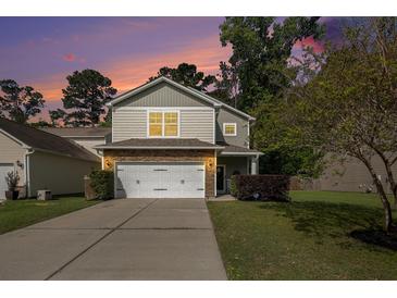 Charming two-story home featuring stone accents, a two-car garage, and a well-manicured front yard at 1723 Indaba Way, Charleston, SC 29414