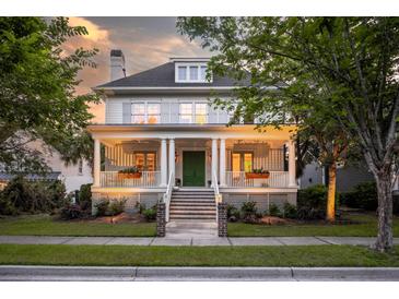 Charming two-story home features a welcoming porch with white columns and a green front door at 2431 Settlers St, Charleston, SC 29492