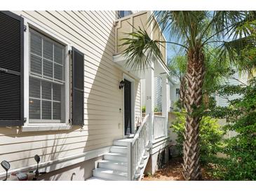 Charming home entrance with white stairs, black door, palm tree, and well-maintained landscaping at 34 Dereef Ct, Charleston, SC 29403