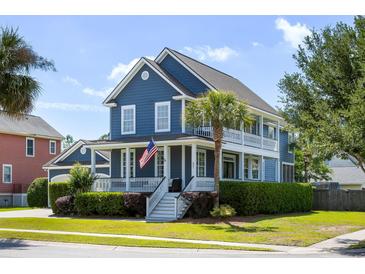 Charming blue two-story home with double porches, a landscaped yard, and an American flag on the front porch at 601 King Haven Ln, Johns Island, SC 29455