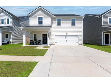 Charming two-story home featuring white siding, a well-manicured lawn, and an attached two-car garage at 112 Whisper Dr, Summerville, SC 29485