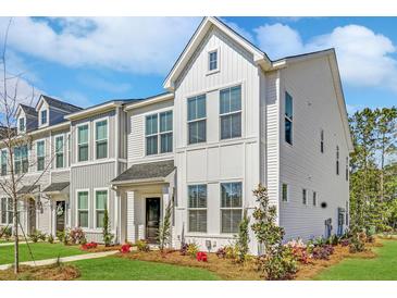 Charming new construction townhome with light siding, lovely landscaping, and a welcoming front entrance at 121 Brown Swiss Cir, Summerville, SC 29483