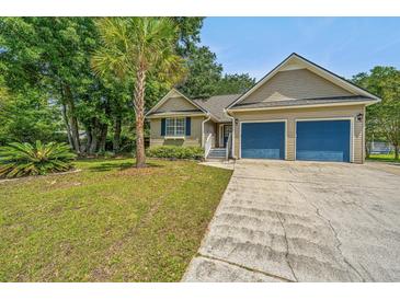 Charming single-story home featuring a two-car garage, driveway and well-manicured lawn with palm tree at 1918 Piper Dr, Charleston, SC 29407