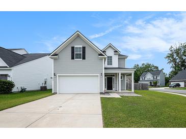 Charming two-story home with gray siding, attached garage, and well-maintained front yard at 313 Catawba Branch Way, Moncks Corner, SC 29461