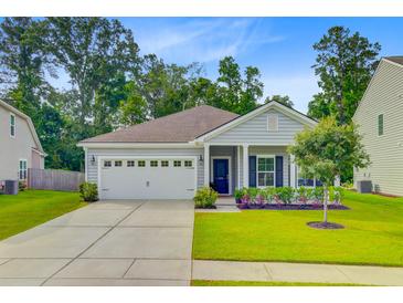 Charming single-story home featuring a manicured lawn, attached two-car garage, and a welcoming front porch at 578 Mountain Laurel Cir, Goose Creek, SC 29445