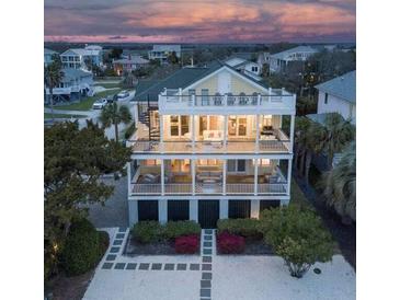 Three-story beach house featuring multiple balconies and a spiral staircase with lush landscaping at 601 Ocean Blvd, Isle of Palms, SC 29451