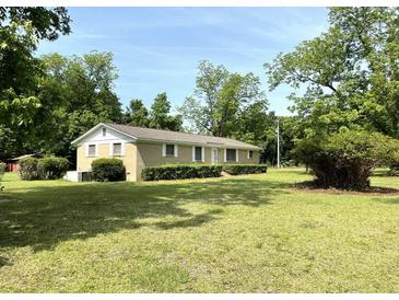 Charming single-story home with a brick facade, lush lawn, and mature trees at 6287 Sniders Hwy, Walterboro, SC 29488