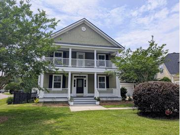 Charming two-story home features a double porch, green lawn, and mature trees enhancing curb appeal at 911 Hunt Club, Charleston, SC 29414