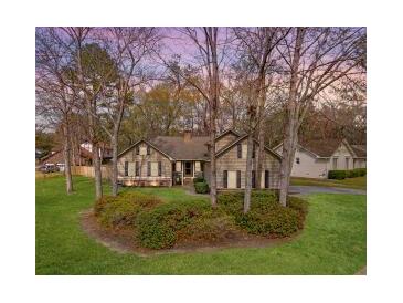 Charming single-story home featuring a well-maintained lawn and a mix of mature trees at 101 Plantation Dr, Summerville, SC 29485