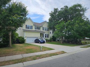 Charming two-story home with a well-manicured lawn, attached garage, and a blue car parked in the driveway at 1495 Keshi Pearl Dr, Mount Pleasant, SC 29466