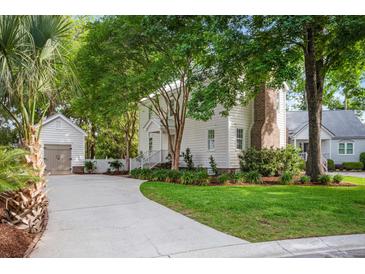 Charming two-story home with lush landscaping, a detached garage, and a winding driveway at 1514 Village Sq, Mount Pleasant, SC 29464